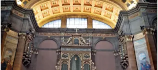 Visitors walk about under the ornate ceiling frescos of McEwan Hall