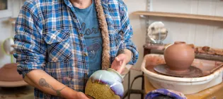 Artist showcasing hand made pottery at studio The Potter of Leith