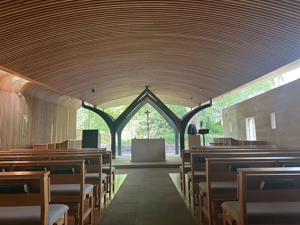 Interior of chapel with full-wall glass window behind the altar. 