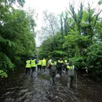 Teaching Operations team wading along the Water of Leith. Staff volunteering.