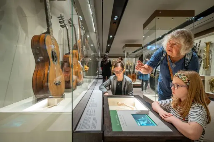 Adult and child viewing stringed instruments in St Cecilia's Music Museum. 