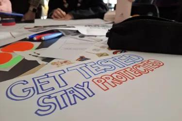 handwritten poster reading "get tested, stay protected"