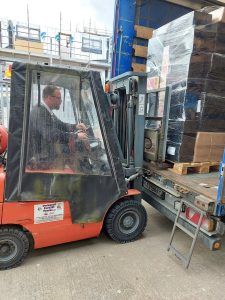 Estates team operating a forklift, helping to sort and transport donations