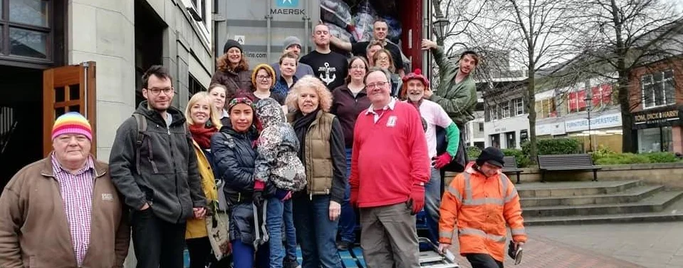 Image shows group of community members and staff members posing for a photo